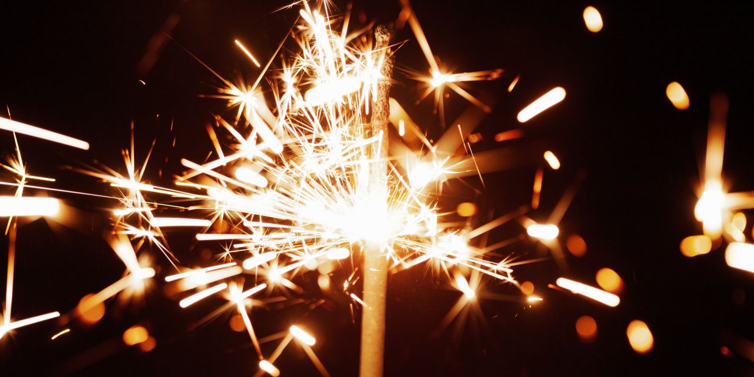 Close-up of golden blurry sparks burn in the dark